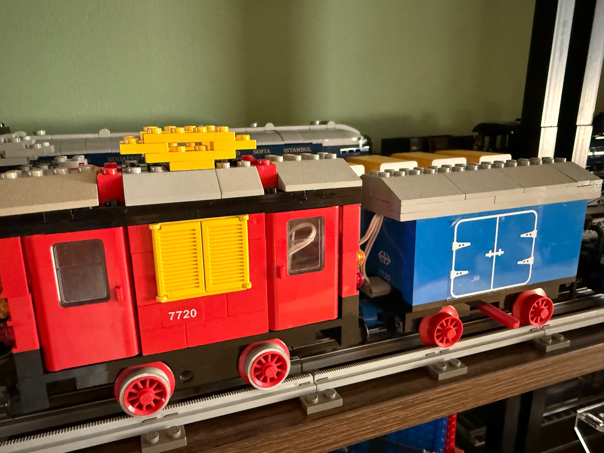 LEGO 7720 locomotive with a blue freight wagon on grey tracks